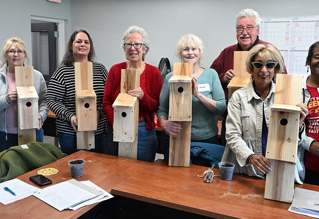 Workshop participants show off their completed birdhouses.
