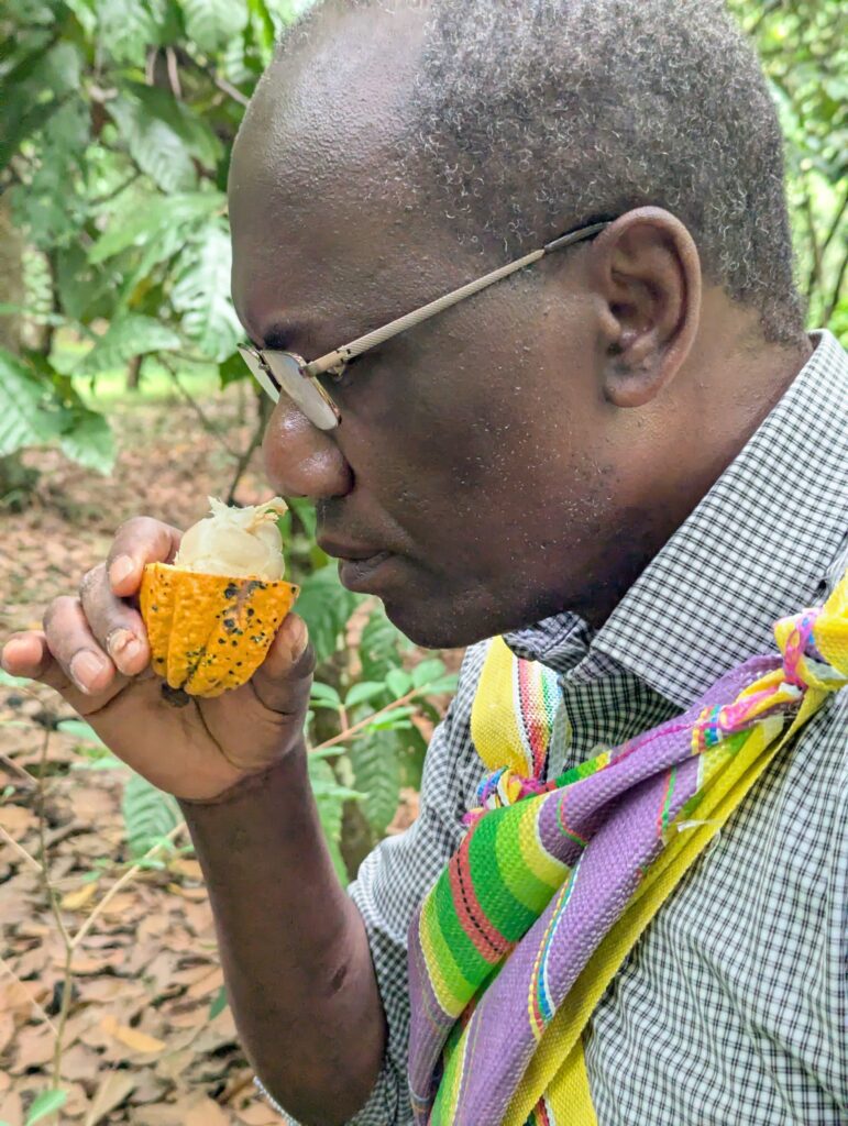 A UMES professor wearing a traditional Incan bag smells a cacao fruit.