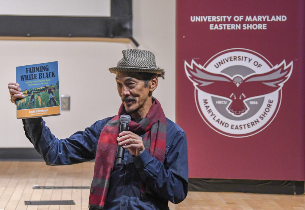 Documentary filmaker Mark Decena holds a "Farming While Black" book, the impetuous for the fim.
