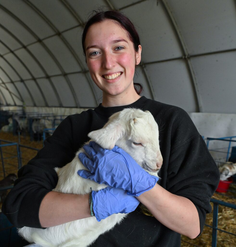 A freshman pre-vet student holds a kid goat at UMES.