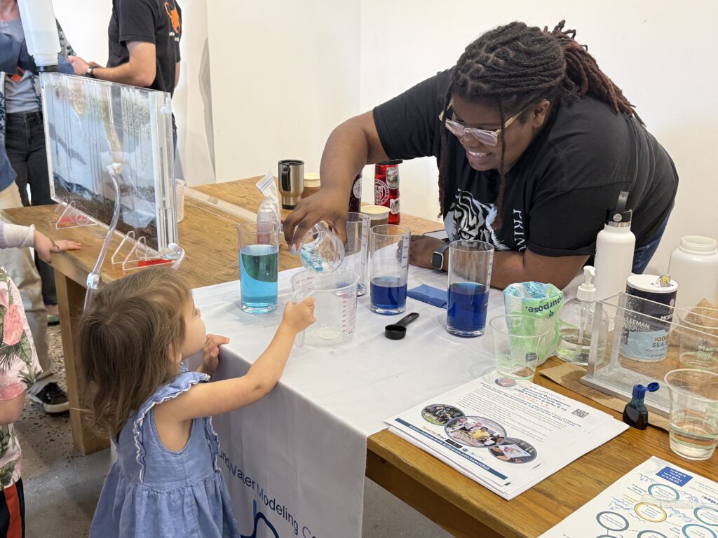 A UMES alumna now working at Princeton helps a child with an experiment during Princeton World Water Day education and outreach event. 