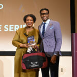 Political candidate stands with student government member.