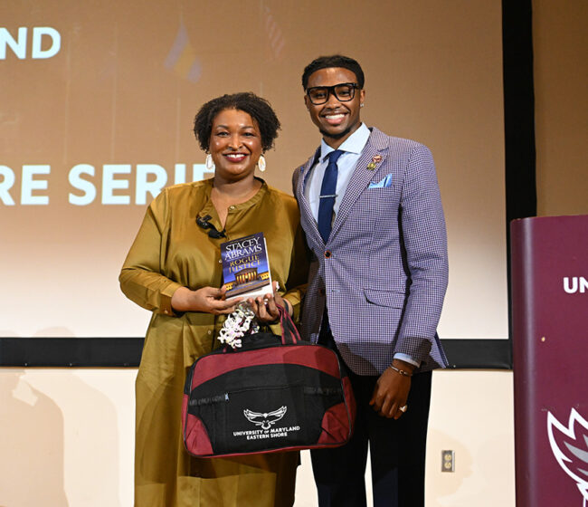 Political candidate stands with student government member.