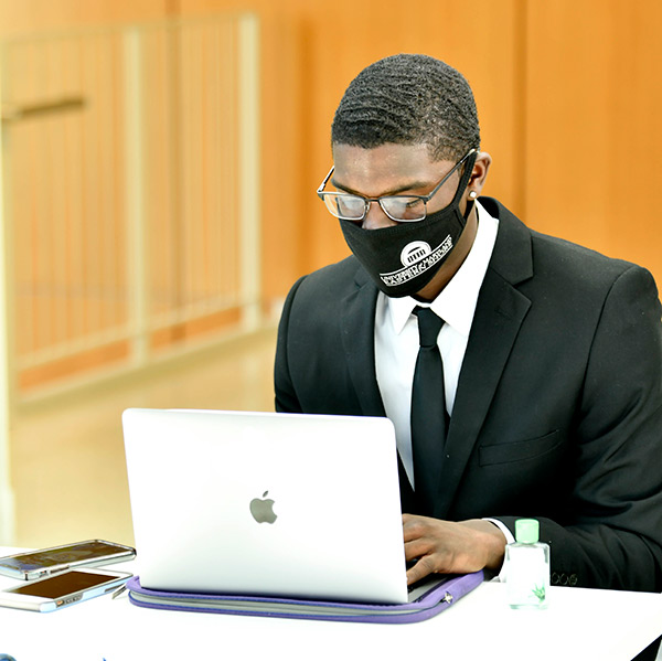 James Webb sitting at a Macbook Computer